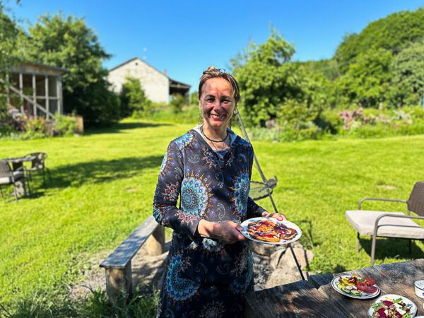 Eine Frau trägt Speisen in einem Garten auf