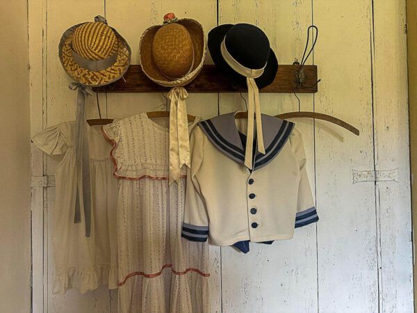 Urlaub in der Kaschubei: Kinderkleider und Kinderhüte aus dem frühen 20. Jahrhundert hängen an der Garderobe