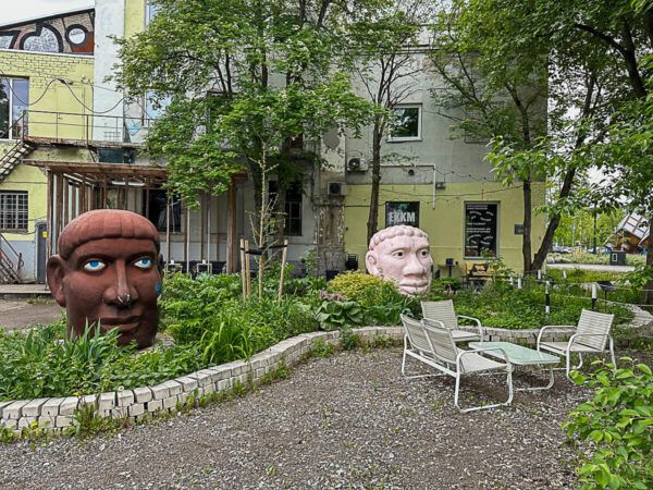Zwei skulptierte Köpfe vor einem Museumsgebäude