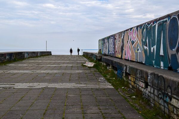 Aufgang zur Linnahall mit zwei Menschen und einer bunt bemalten Wand